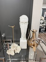 All four decor pieces on glass shelf