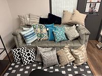 Full lot view showing all pillow pairs on sofa and floor