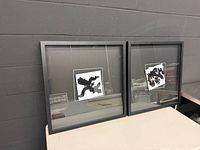 Both framed abstract prints side by side on table