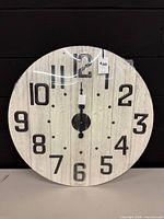 Front view of entire circular wall clock showing numerals and hands