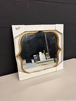 Front view of square mirror with gold frame and corner protectors