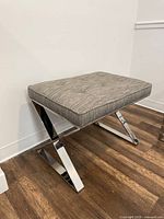 Three-quarter view showing fabric, tufting, and leg style