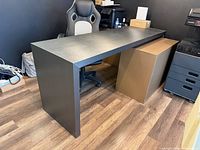 Full view of desk showing rectangular shape, panel legs, gunmetal finish
