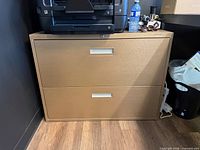 Front view of gold two-drawer filing cabinet under printer