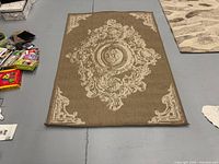 Full view of beige and cream flatwoven rug showing ornate pattern
