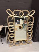 Front view of gold scroll mirror showing full frame and glass