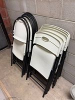Stacked plastic folding chairs showing both styles and overall condition