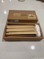 Open box showing multiple paper-sleeved glass straws and one loose straw sample