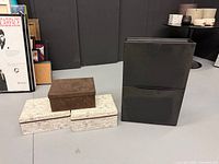 Full lot showing two cream script boxes, one brown box on top, and black IKEA shoe cabinet