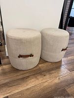 Pair of beige Korson Alto Drum stools on wood floor