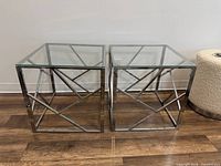Pair of square stainless steel frame side tables with glass tops