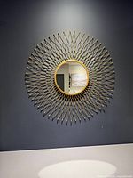 Full view of gold sunburst mirror on wall
