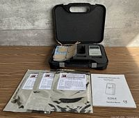 Closed case open showing stimulator, electrode pad set, sealed electrode packs and manual