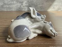 Front right view of porcelain figurine showing pig faces and coloration