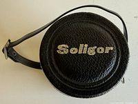Top view of black leatherette Soligor case with strap