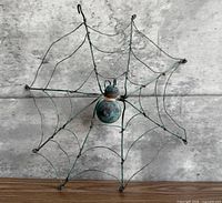 Full view of wire spiderweb ornament with spider