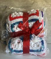 Blanket in plastic wrap with red ribbon