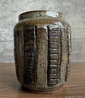 Full view of vase front showing glaze and vertical textured panels