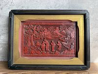 Frontal view of framed cinnabar carving