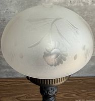 Etched floral details on frosted glass orb shade
