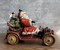 Left side profile of porcelain Santa in antique car with toys