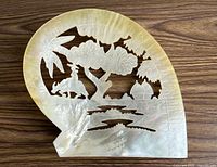Front view of entire shell plaque showing carved landscape scene