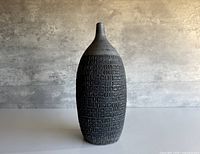 full view front of textured dark grey stoneware bottle-form vase