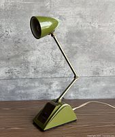 Side view showing full lamp with green shade, brass arm, base