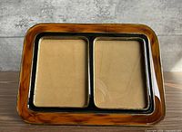 Front view showing amber enamel tortoiseshell frame and two photo openings