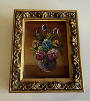 Front view showing floral painting and ornate frame