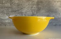 Side profile showing yellow exterior and footed base