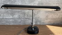 Front view of black adjustable desk lamp with horizontal shade