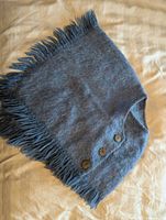 Full view of blue fringed shawl with three buttons