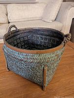 Angled view of basket showing woven sides, handles, rim and corner reinforcements