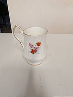 Side view of cup showing floral design and gold rim