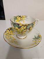 Teacup on saucer showcasing floral design and gold trim