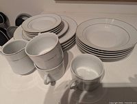 Stacks of plates, bowls, cups and creamer pitcher