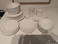 Group view of all plates, bowls, platter, creamer and sugar