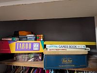 Stacked board games, book and Rubik’s Cube on shelf