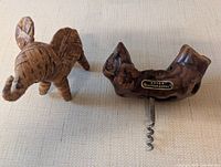 Wood corkscrew with branded plaque beside woven grass elephant
