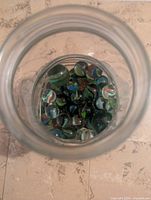 Top view into jar showing numerous coloured marbles