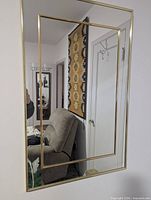 gold-tone framed wall mirror front view