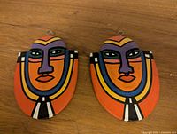 Front view of both colourful wooden carvings