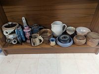 Full shelf showing all pottery pieces arranged together