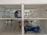 Cabinet shelves showing variety of clear and coloured stemware sets