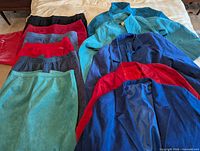 Group shot of all five coats and six skirts laid on bed showing colour range