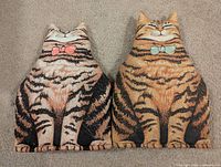 Front view of both cat tea cozies showing designs and colors