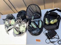 Four aviation headsets on table with coiled cables and carrying cases visible