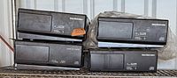 Four Delco Electronics CD changers stacked on shelf