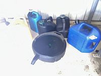 Group view of five fuel cans and oil drain pan